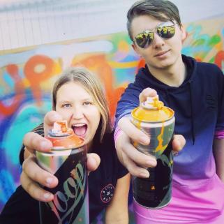 children holding graffiti cans towards the camera