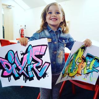 Child holding graffiti artwork