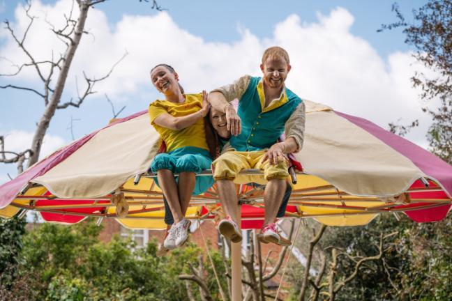 Cast of circus show sat on parasol